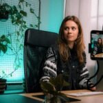 woman in black and white zip up jacket sitting on black office rolling chair